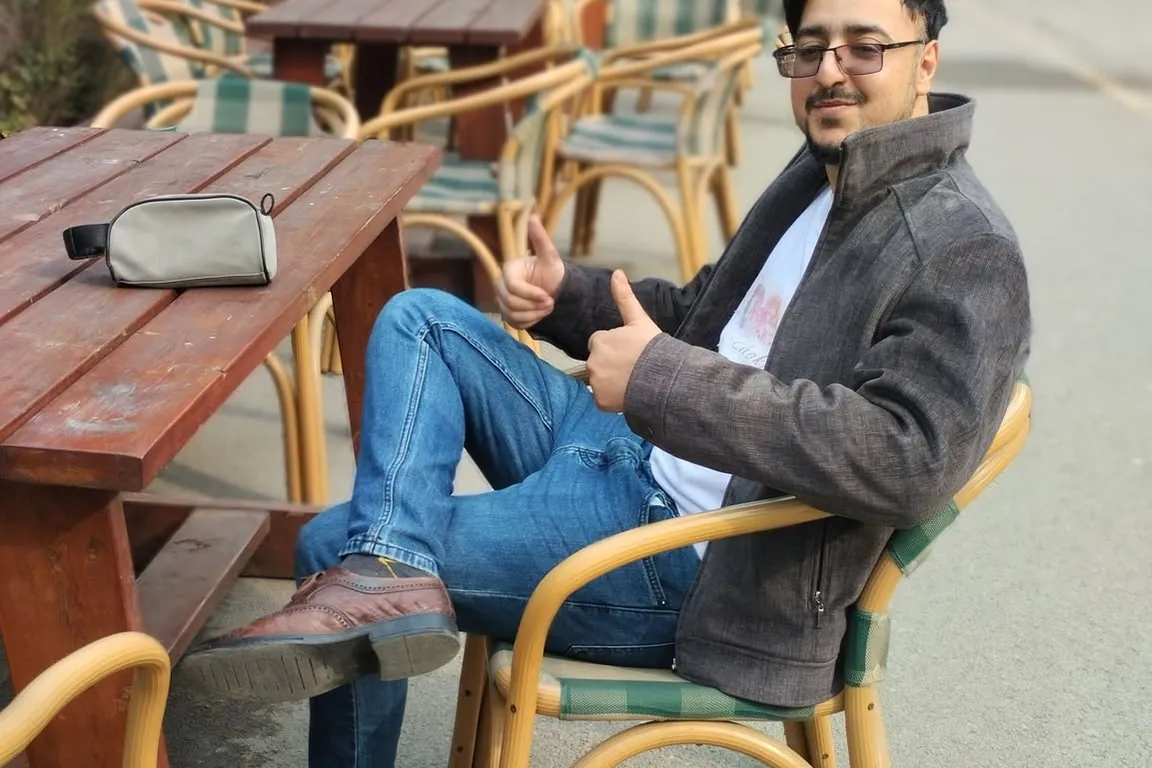 Ahmed Hussain relaxing at an outdoor café table, ready to talk coffee