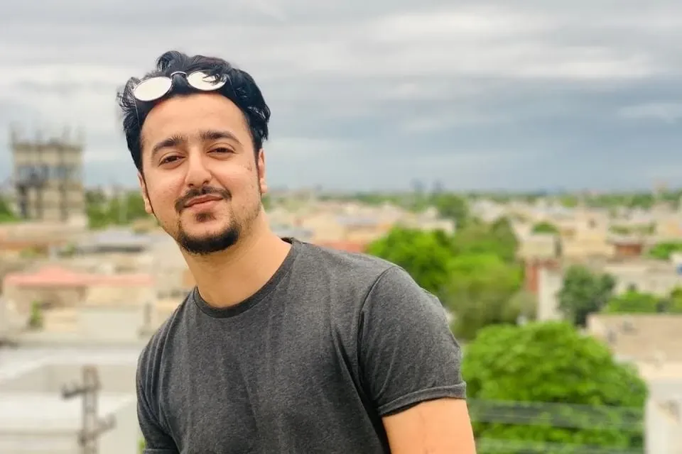 Ahmed Hussain on a rooftop in Lahore with the city behind him