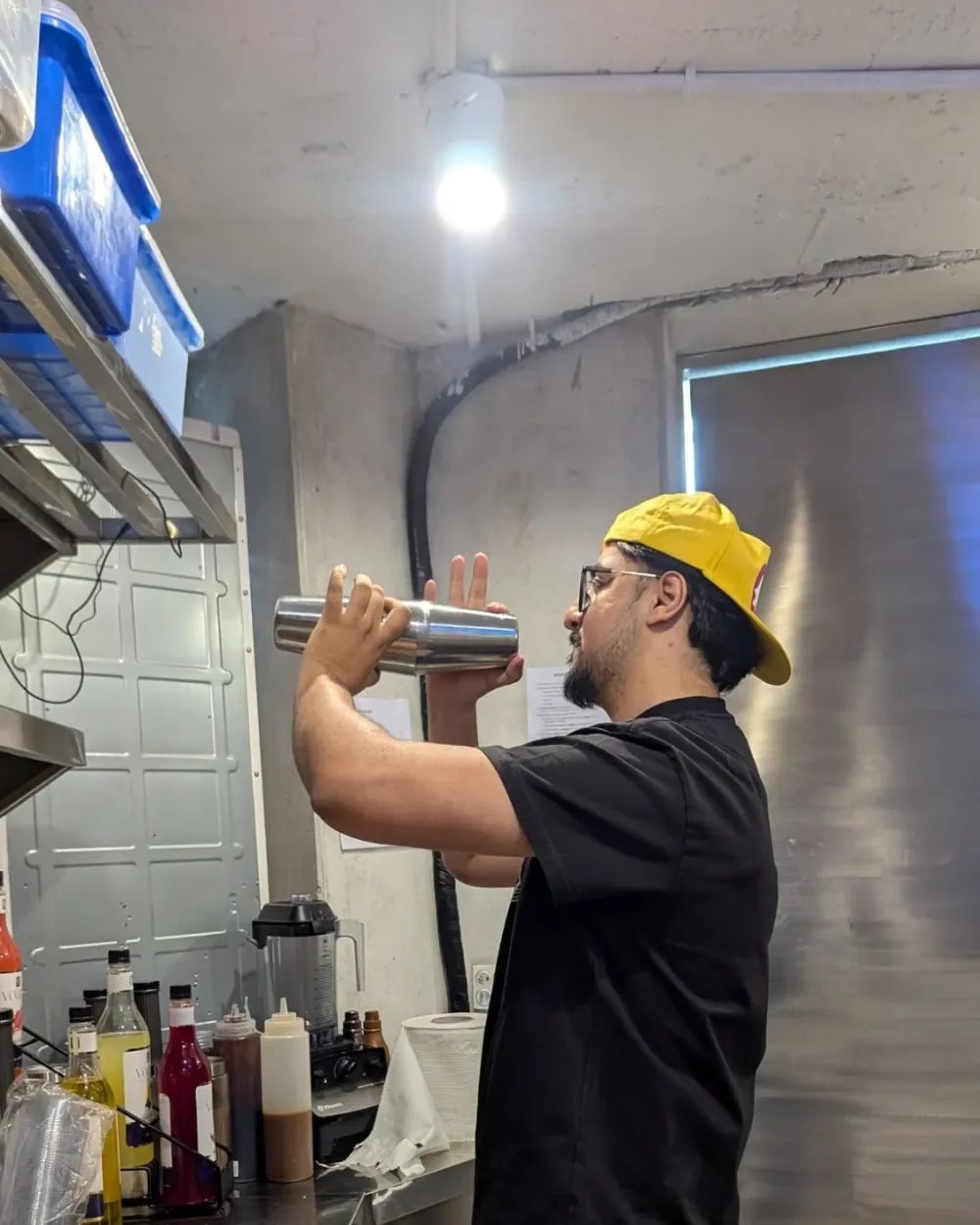 Ahmed Hussain shaking a signature iced coffee drink behind the bar