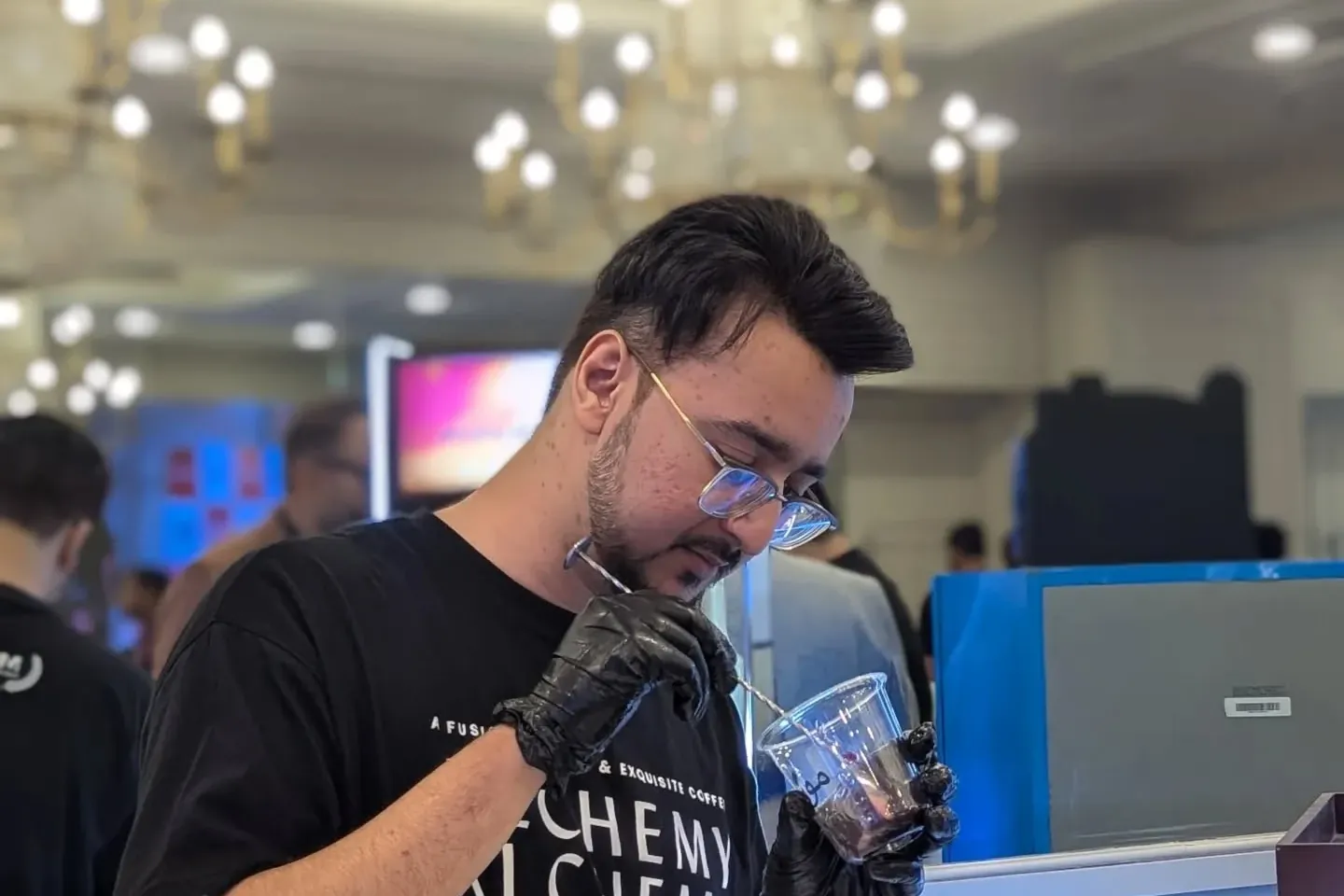 Ahmed Hussain finishing a signature coffee drink at a coffee event