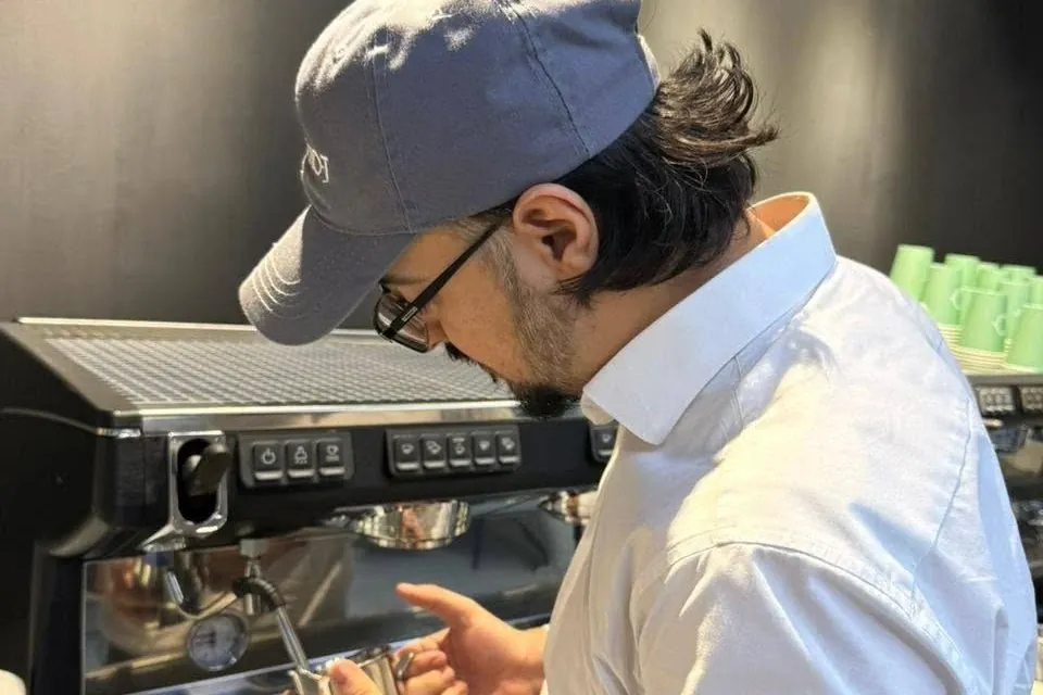 Ahmed Hussain steaming milk for latte art during barista training
