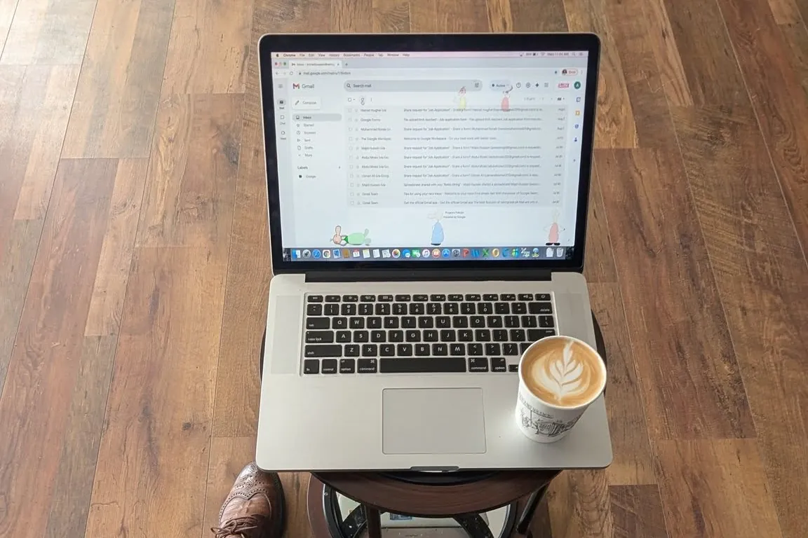 Laptop and a latte on a café table while planning a coffee shop budget